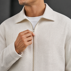 Close-up of the beige lapel jacket collar, zipper and textured weave.