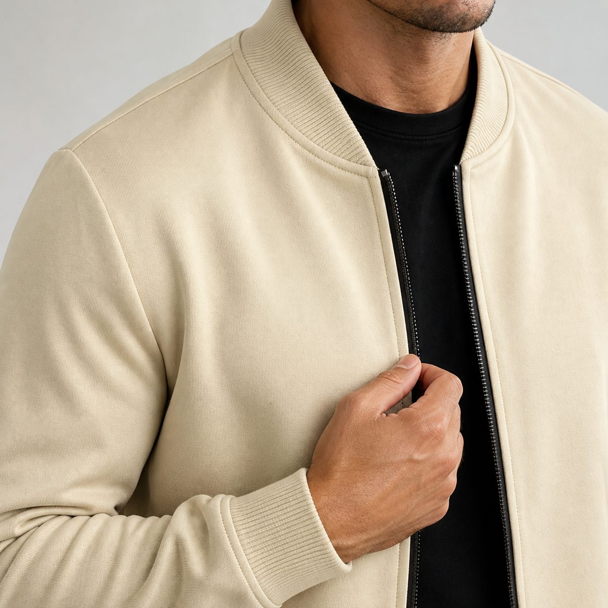 Close-up of the khaki lightweight bomber jacket collar, zipper and ribbed cuff.