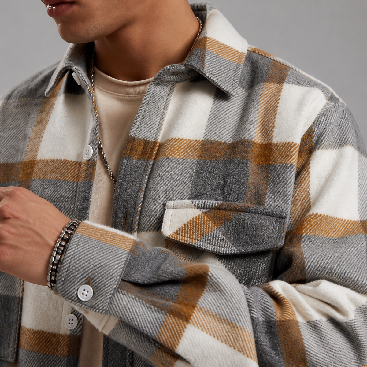 Close-up of the plaid overshirt jacket collar, buttons, chest pocket and woven pattern.