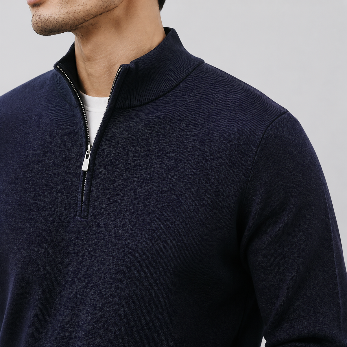 Close-up of the navy quarter zip sweater stand collar, zipper and smooth knit texture.