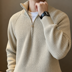 Close-up of the beige quarter zip sweater stand collar, zipper and ribbed knit texture.