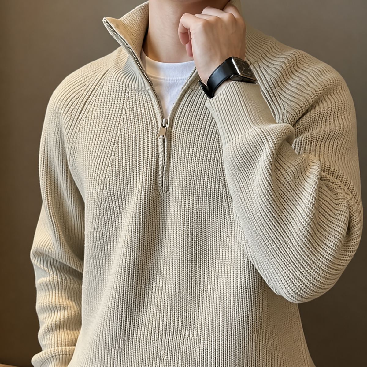 Close-up of the beige quarter zip sweater stand collar, zipper and ribbed knit texture.