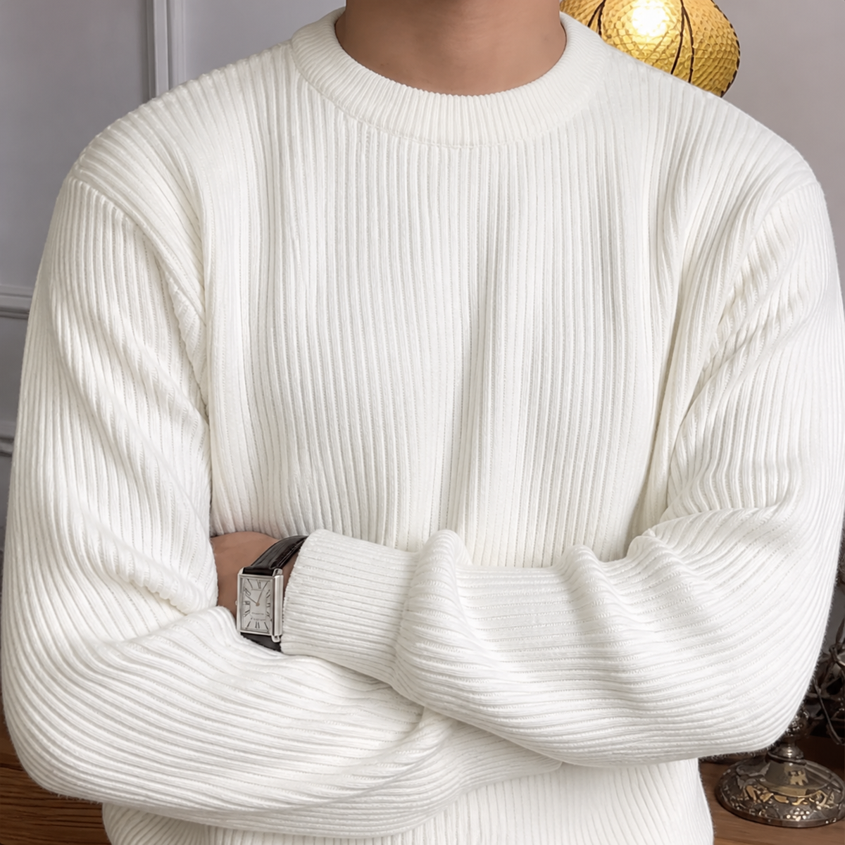 Close-up of the ivory white ribbed crew neck sweater neckline and vertical knit texture.