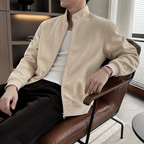 Apricot smooth finish stand collar jacket worn seated indoors in a relaxed lifestyle pose.