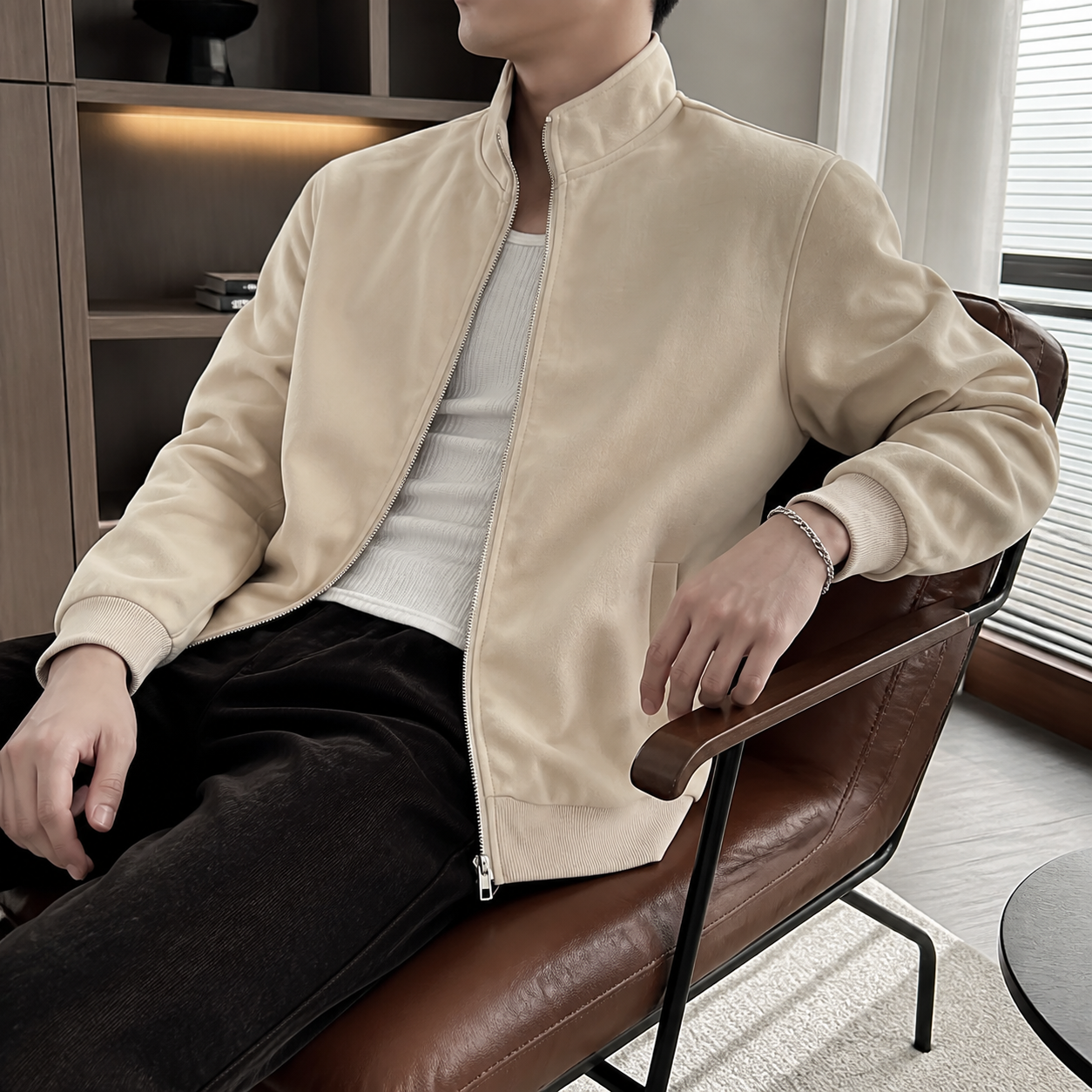 Apricot smooth finish stand collar jacket worn seated indoors in a relaxed lifestyle pose.