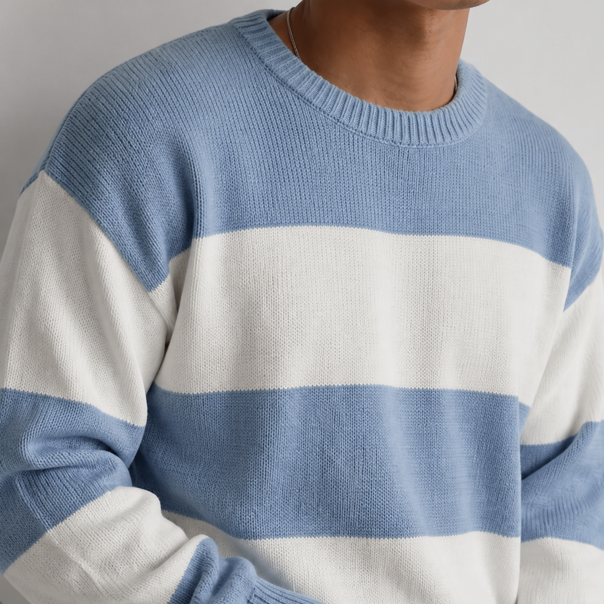 Close-up of the light blue striped crew neck sweater neckline, stripes and knit texture.