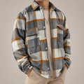 Grey white and brown plaid overshirt jacket on a male model in a clean studio.