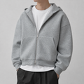Light grey drop shoulder zip up hoodie on a male model in a clean studio.