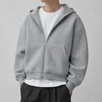 Light grey drop shoulder zip up hoodie on a male model in a clean studio.